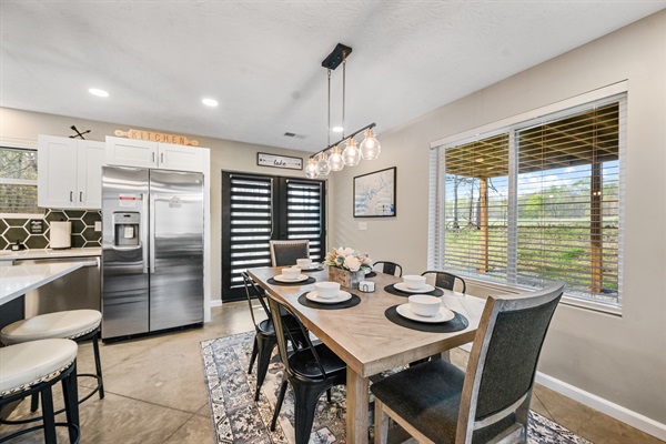 Enjoy meals with a view—the dining table sits beside a large window overlooking the peaceful cow pasture, with two extra seats available at the kitchen island.