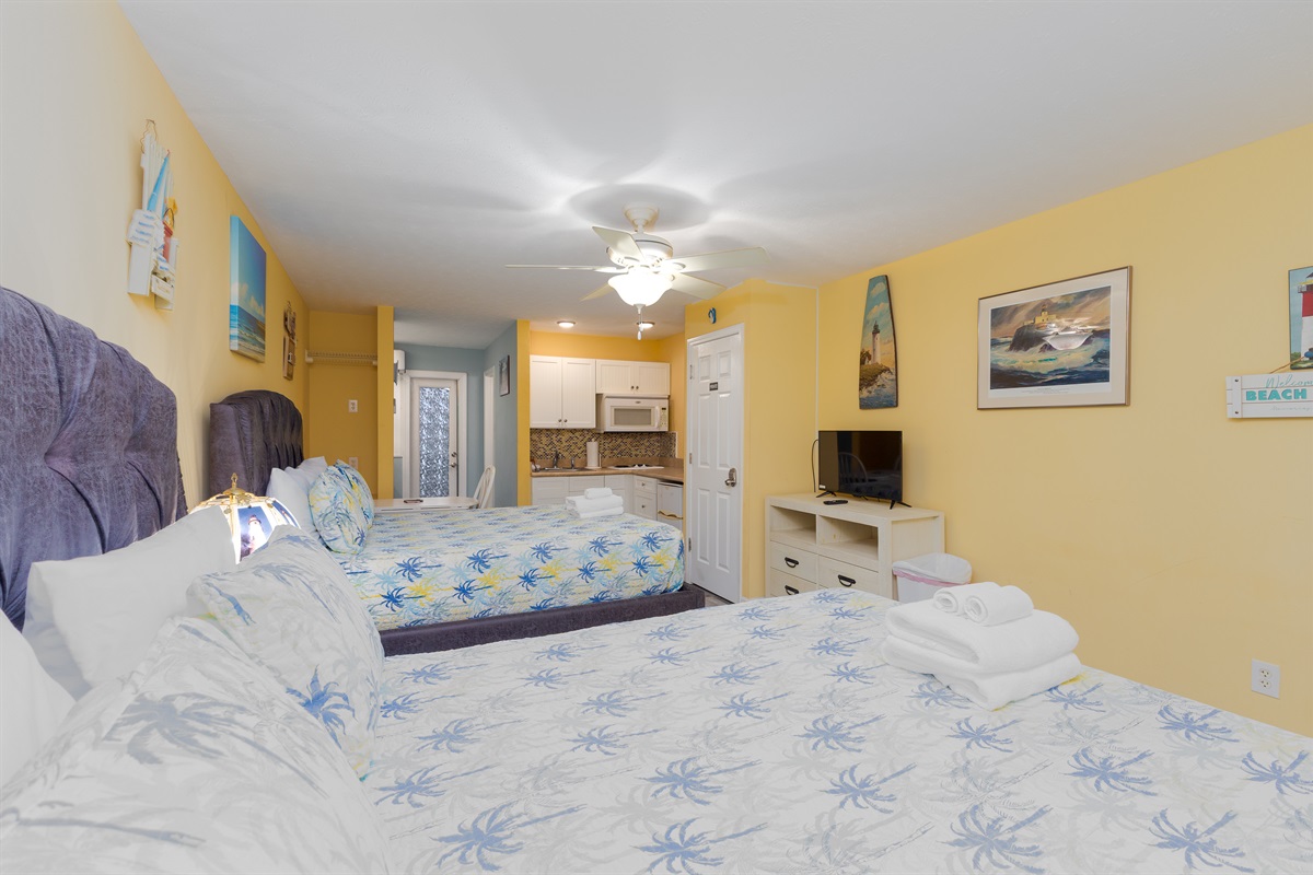 Bright, open studio-style space featuring two comfortable queen beds, coastal d&eacute;cor, and a smart TV for relaxing downtime