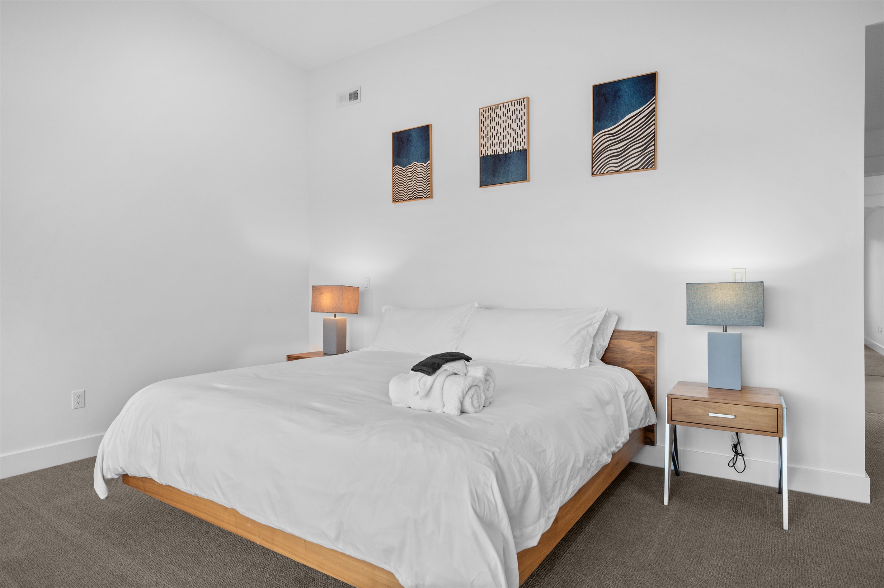 Spacious king bedroom with modern décor and calming neutral tones.