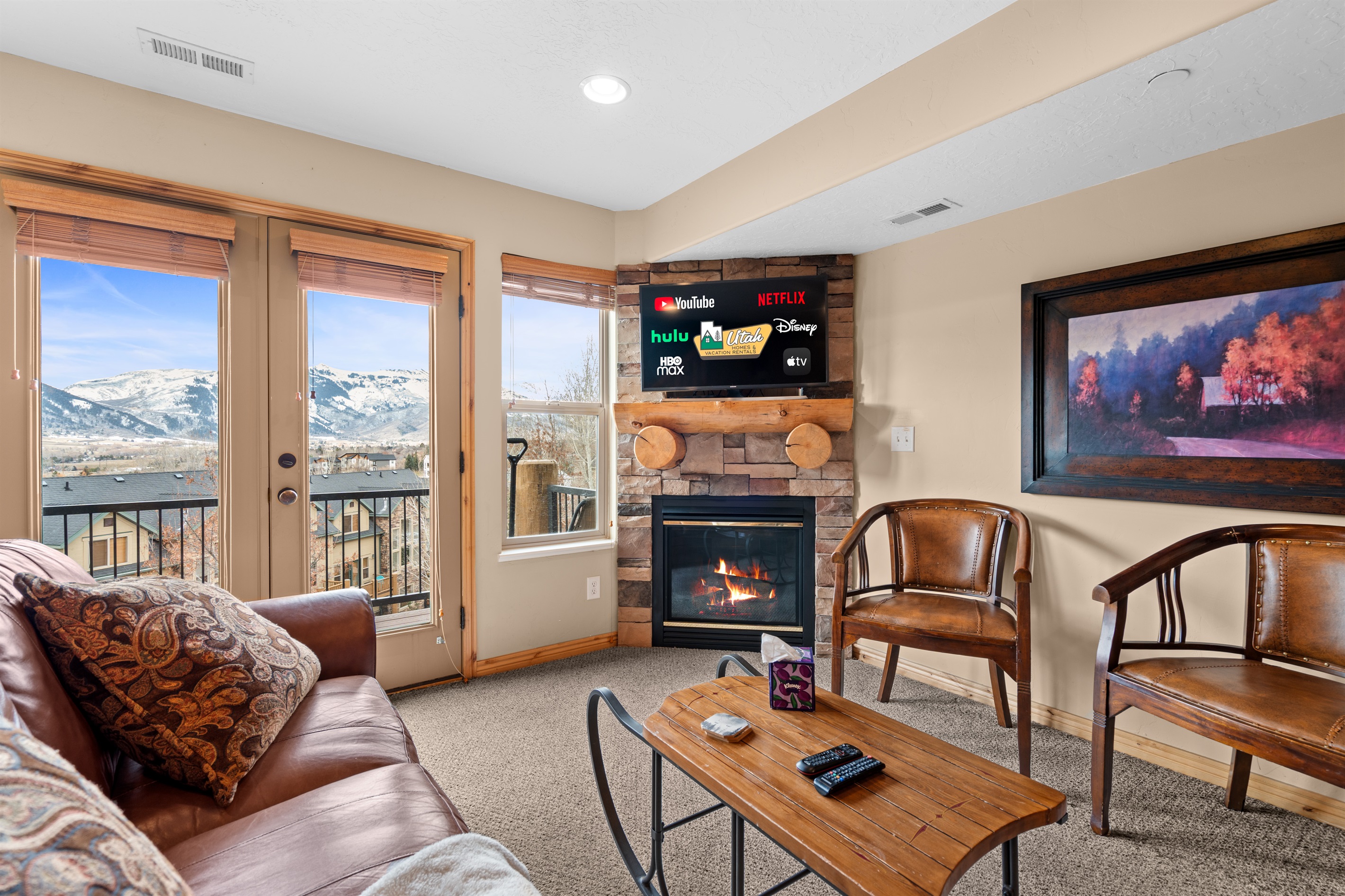 Cozy seating gathered around the fireplace with stunning valley views — ideal for après-ski evenings.