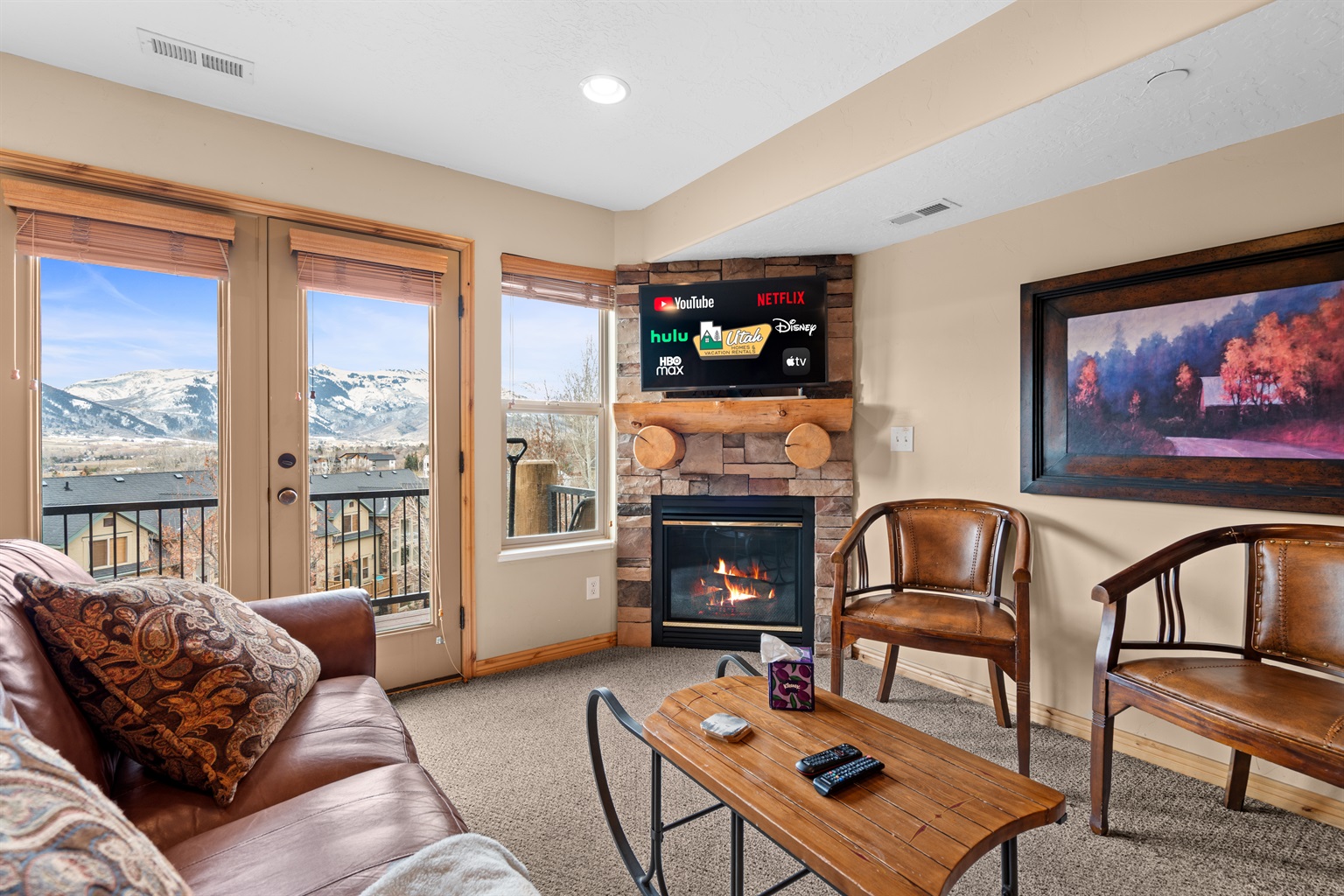 Cozy seating gathered around the fireplace with stunning valley views — ideal for après-ski evenings.