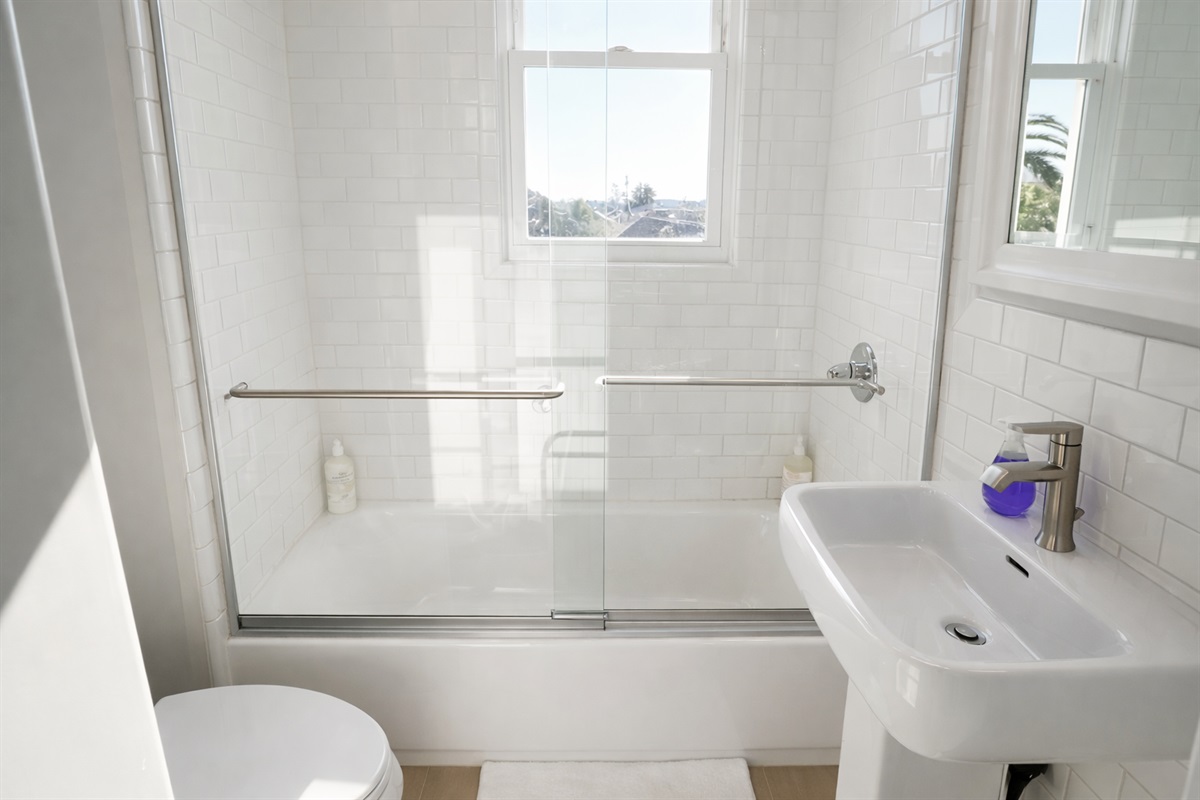 A clean and bright full bath featuring a subway-tiled tub/shower combo and modern fixtures.