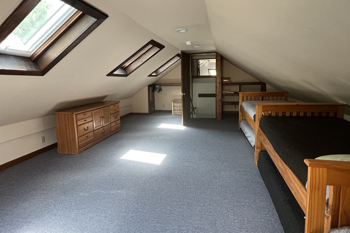 Loft bunk bedroom #3 with 3 twins and trundles view of the private stairwell leading to the loft.