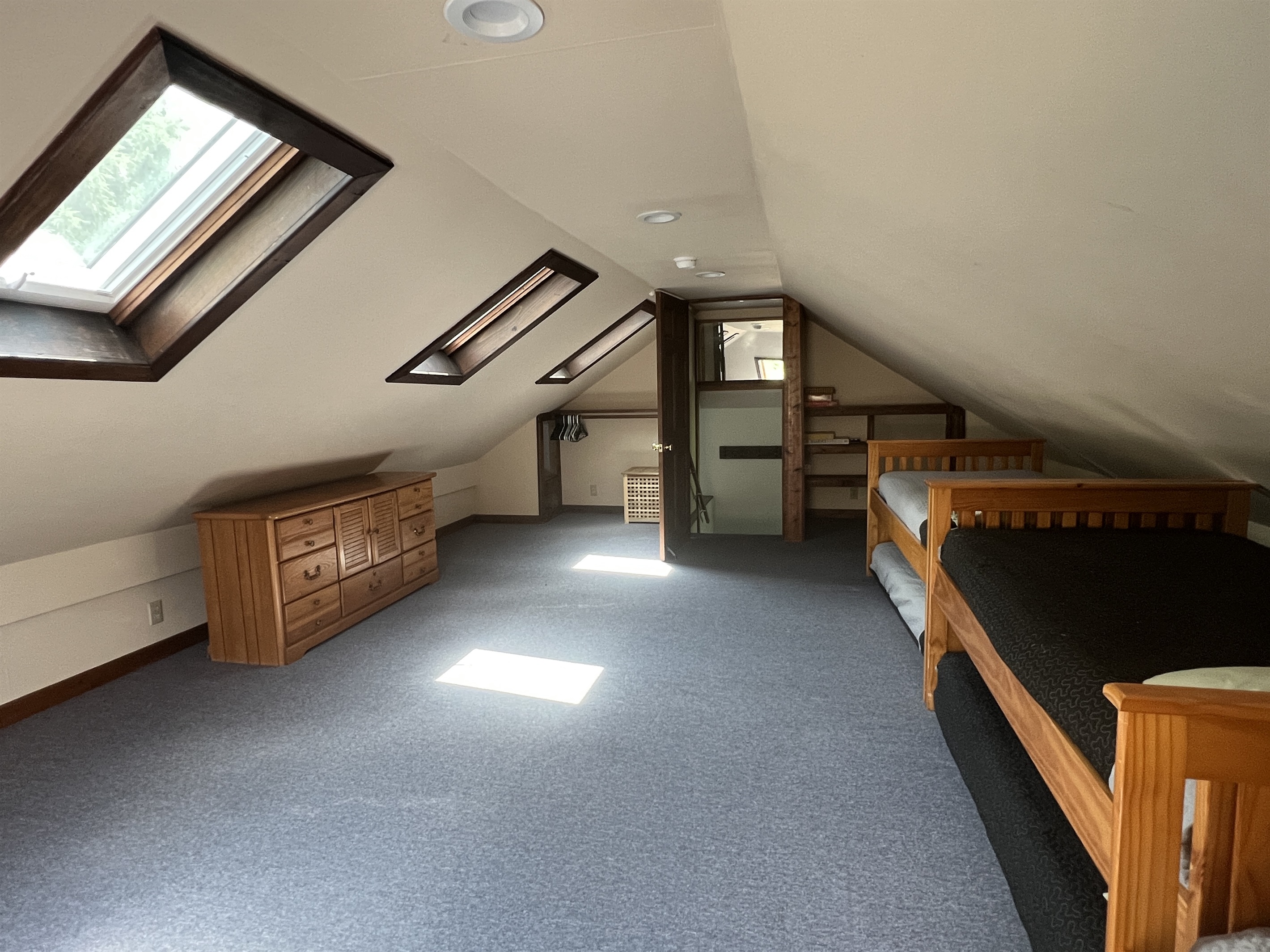 Loft bunk bedroom #3 with 3 twins and trundles view of the private stairwell leading to the loft.