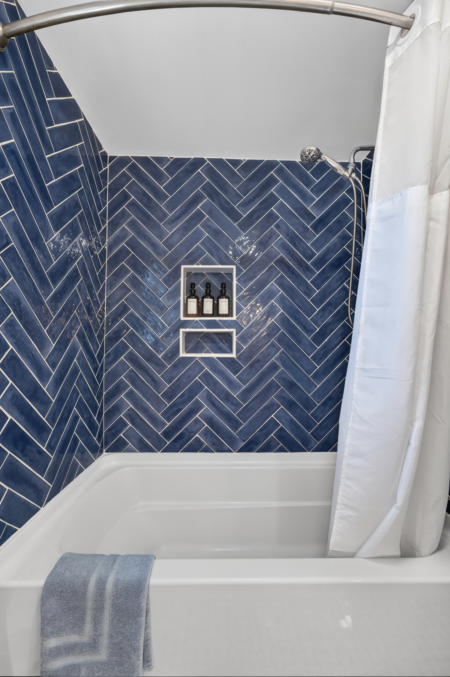 Beautiful walk-in shower featuring stylish tile and a built-in niche for toiletries.