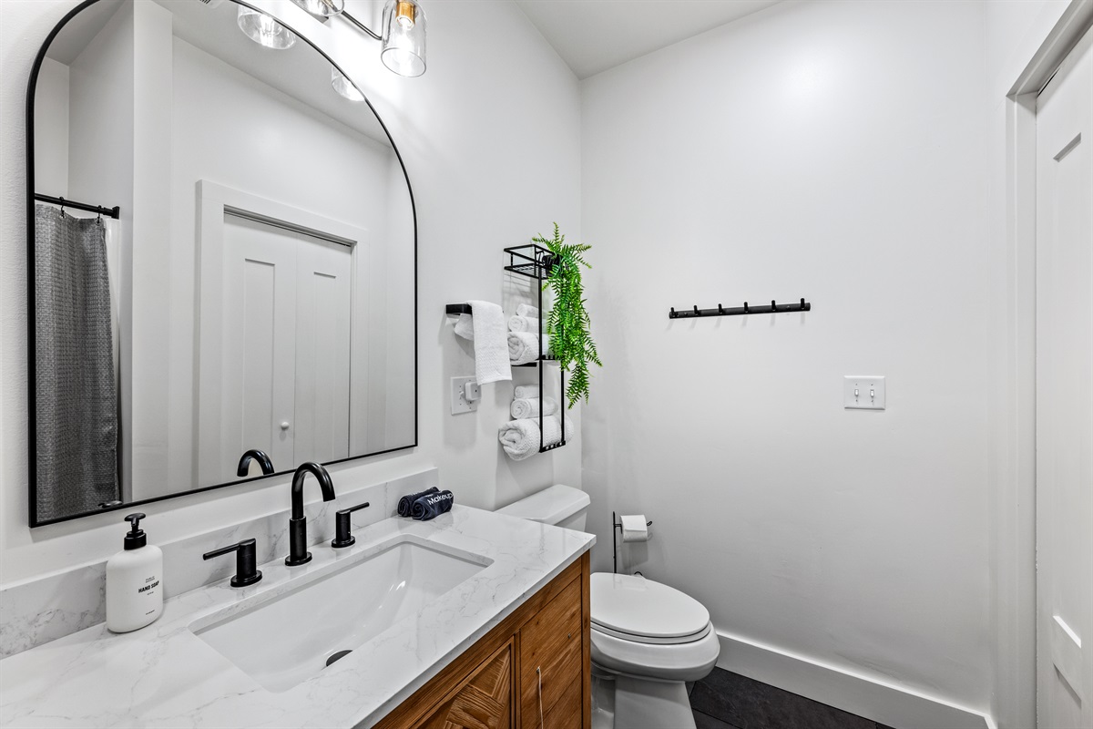 This shared-access bathroom is great for families or couples, with a tub/shower combo, black fixtures, and fresh, modern styling.