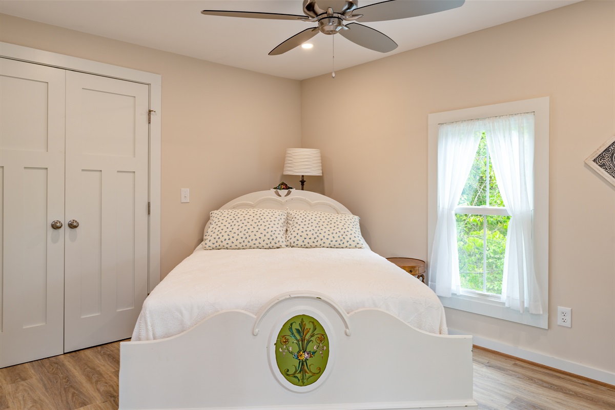 Charming bedroom with unique décor, a ceiling fan, and crisp white bedding for comfort and style. Bedroom #2 Double