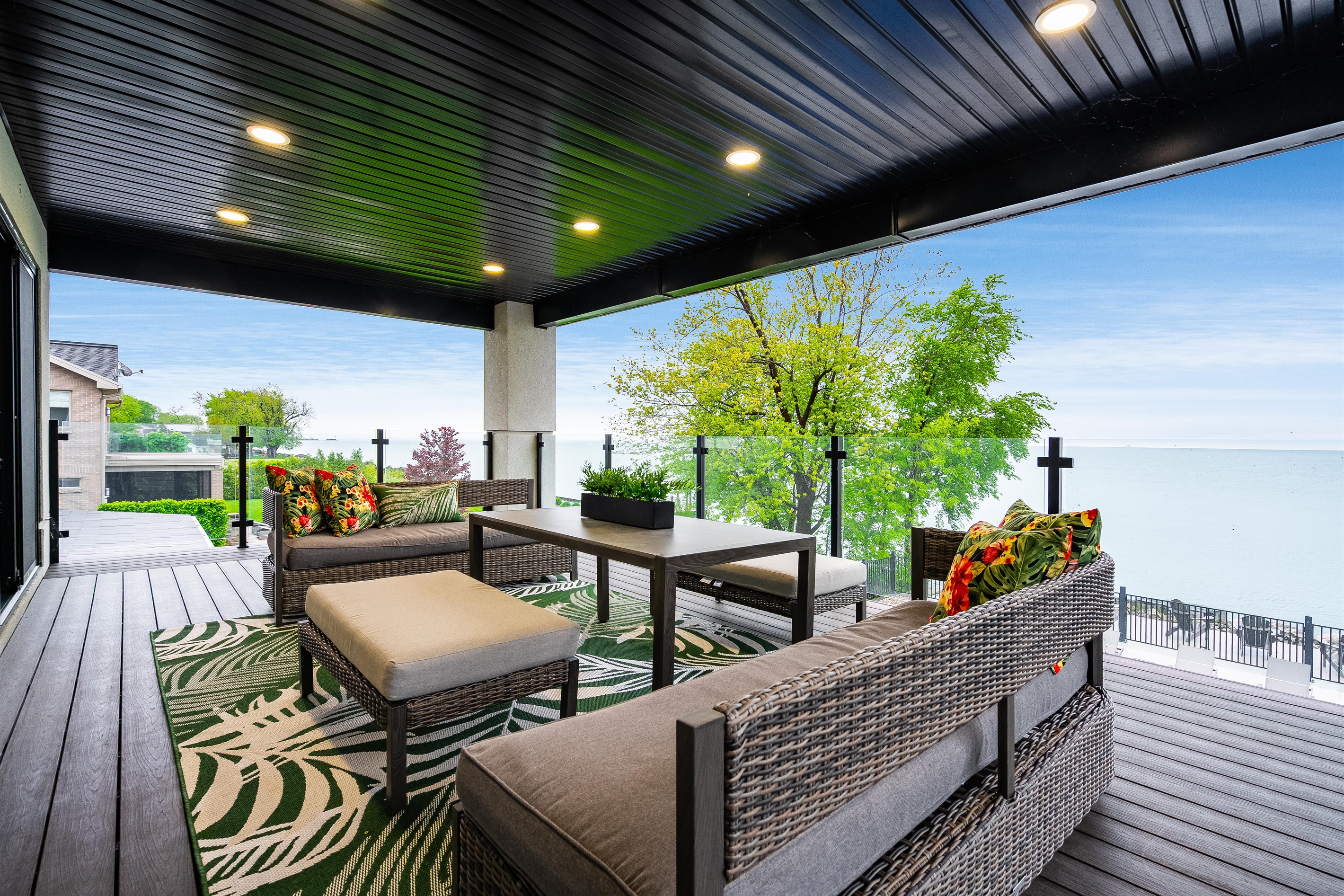 Covered lake view balcony with comfortable outdoor furniture and stunning lake views.