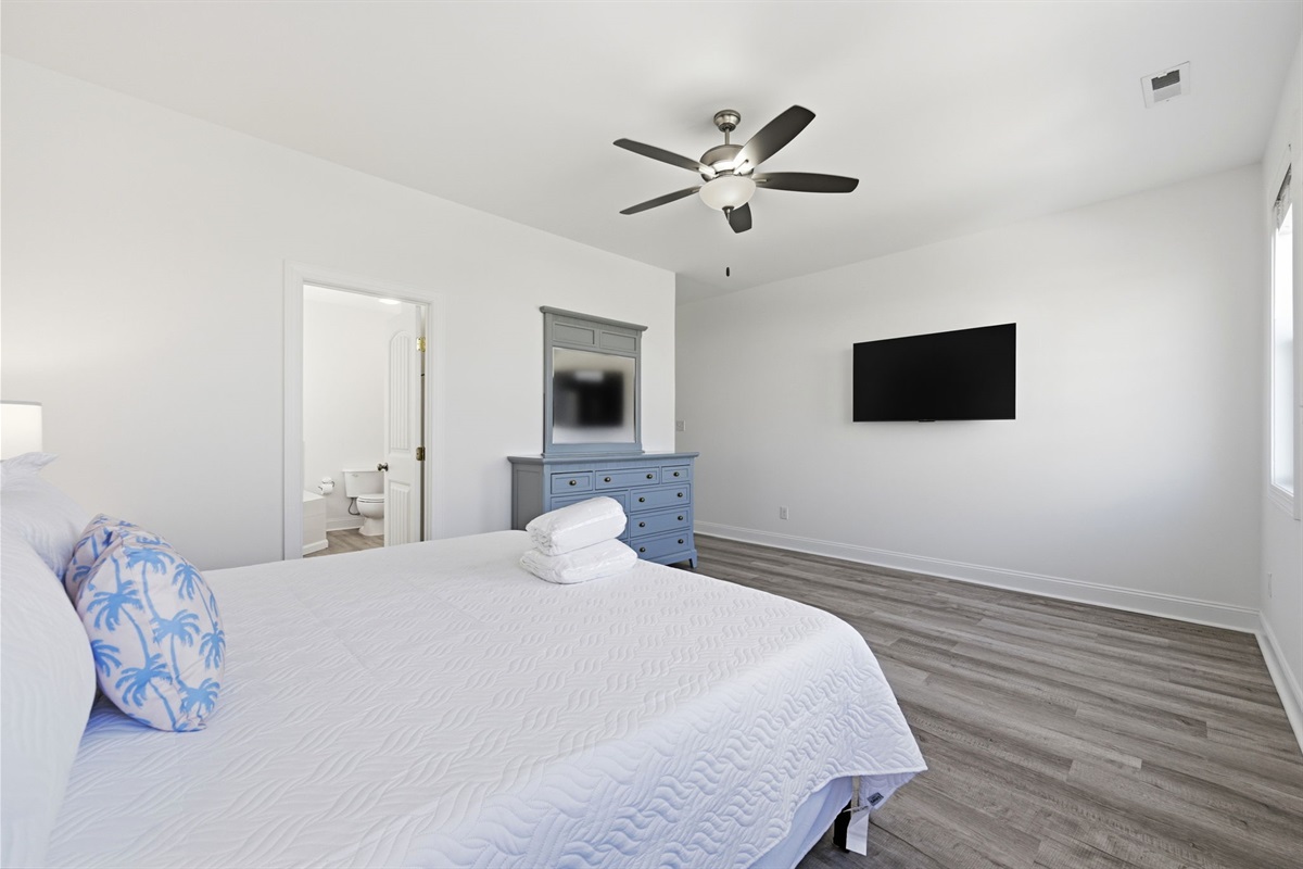 Relax in the oversized king master bedroom featuring a private ensuite and peaceful water views