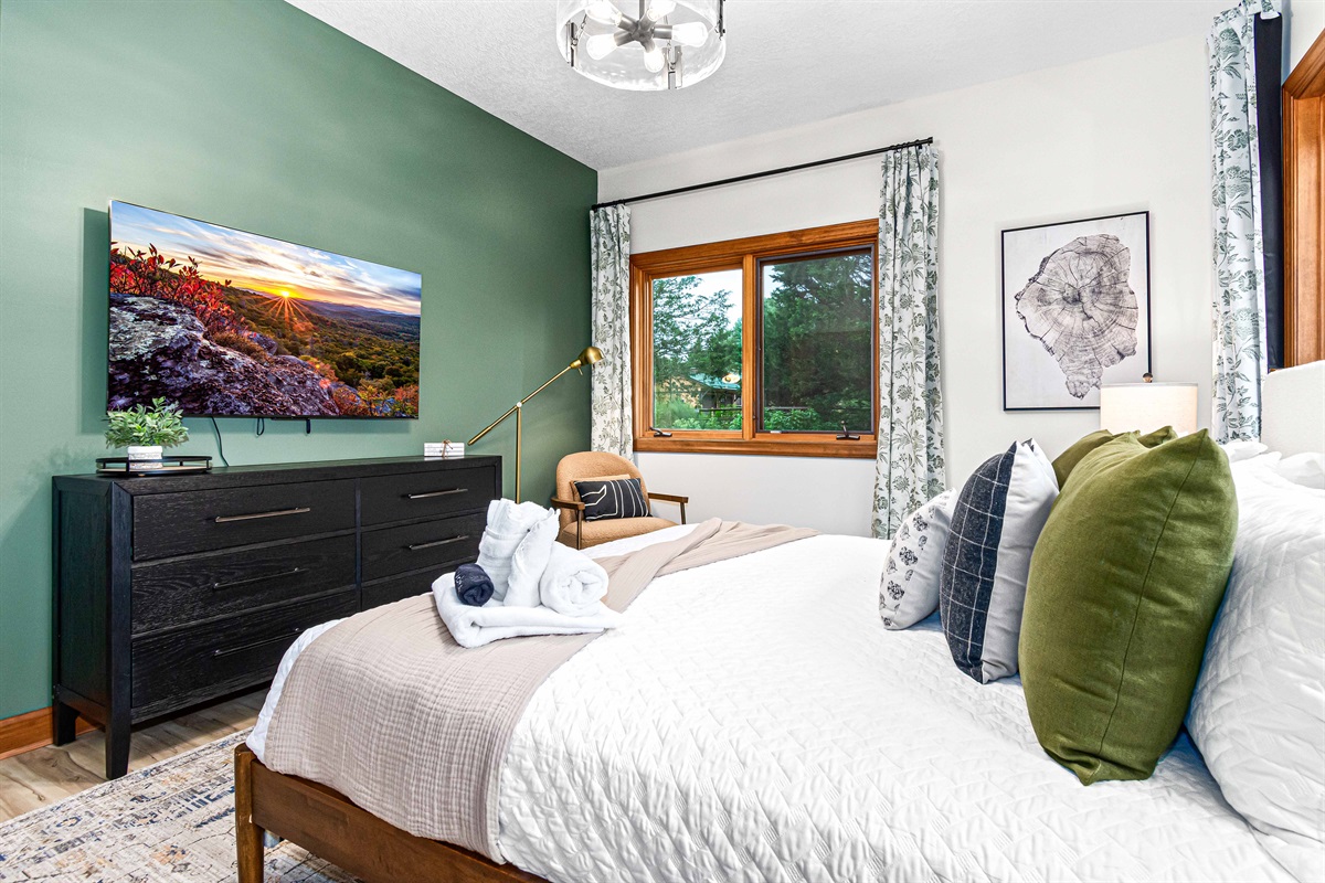 Wake up refreshed with serene views right from your bed—this guest suite blends modern comfort with a calming natural backdrop.🌲🛏️✨