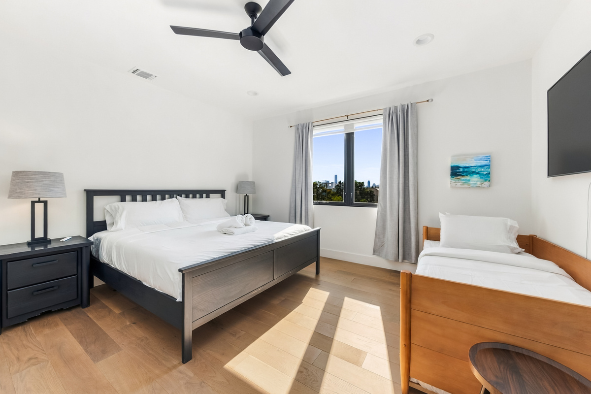 King bed anchors the primary suite, with a twin bed for extra guests.