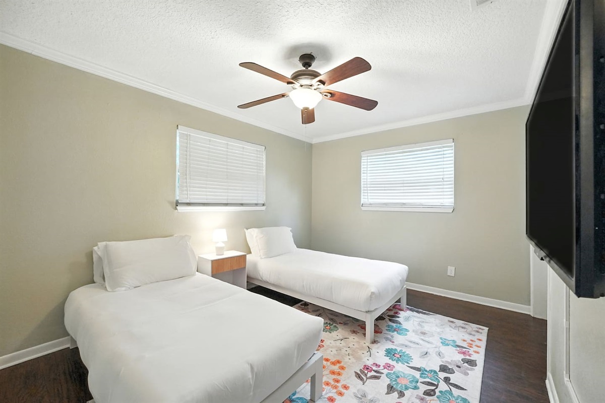 Guest bedroom with 2 twin beds and 50" smart tv