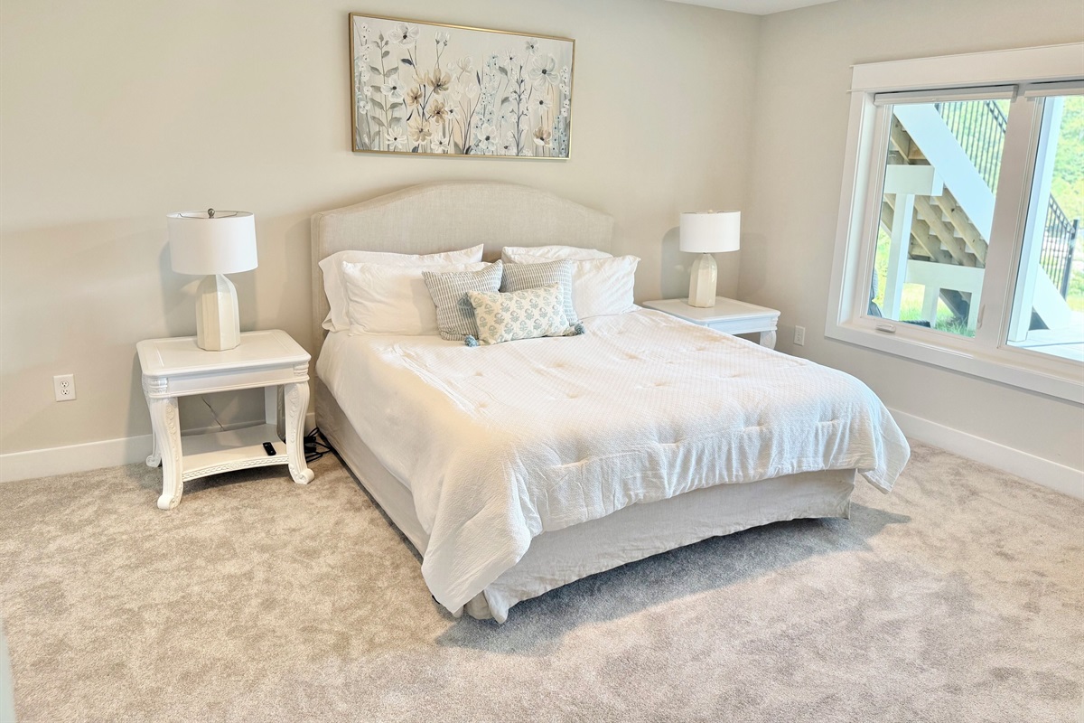 Guests will feel spoiled in this lower level king suite! Our high-end Restoration Hardware signature collection bed is dressed with a thick luxury white comforter that exudes a timeless elegance. We have layered the bedding for comfort and beauty!