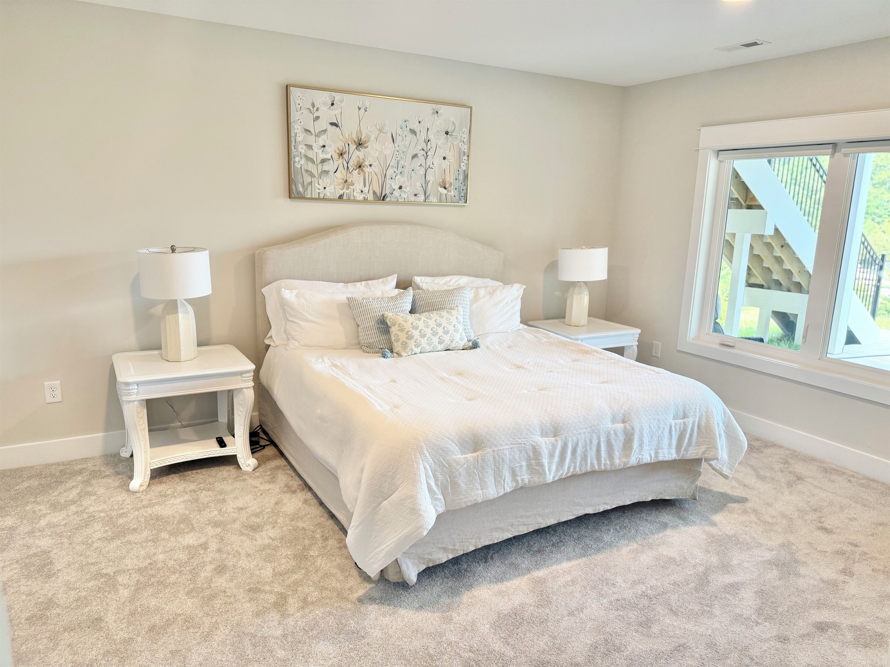 Guests will feel spoiled in this lower level king suite! Our high-end Restoration Hardware signature collection bed is dressed with a thick luxury white comforter that exudes a timeless elegance. We have layered the bedding for comfort and beauty!