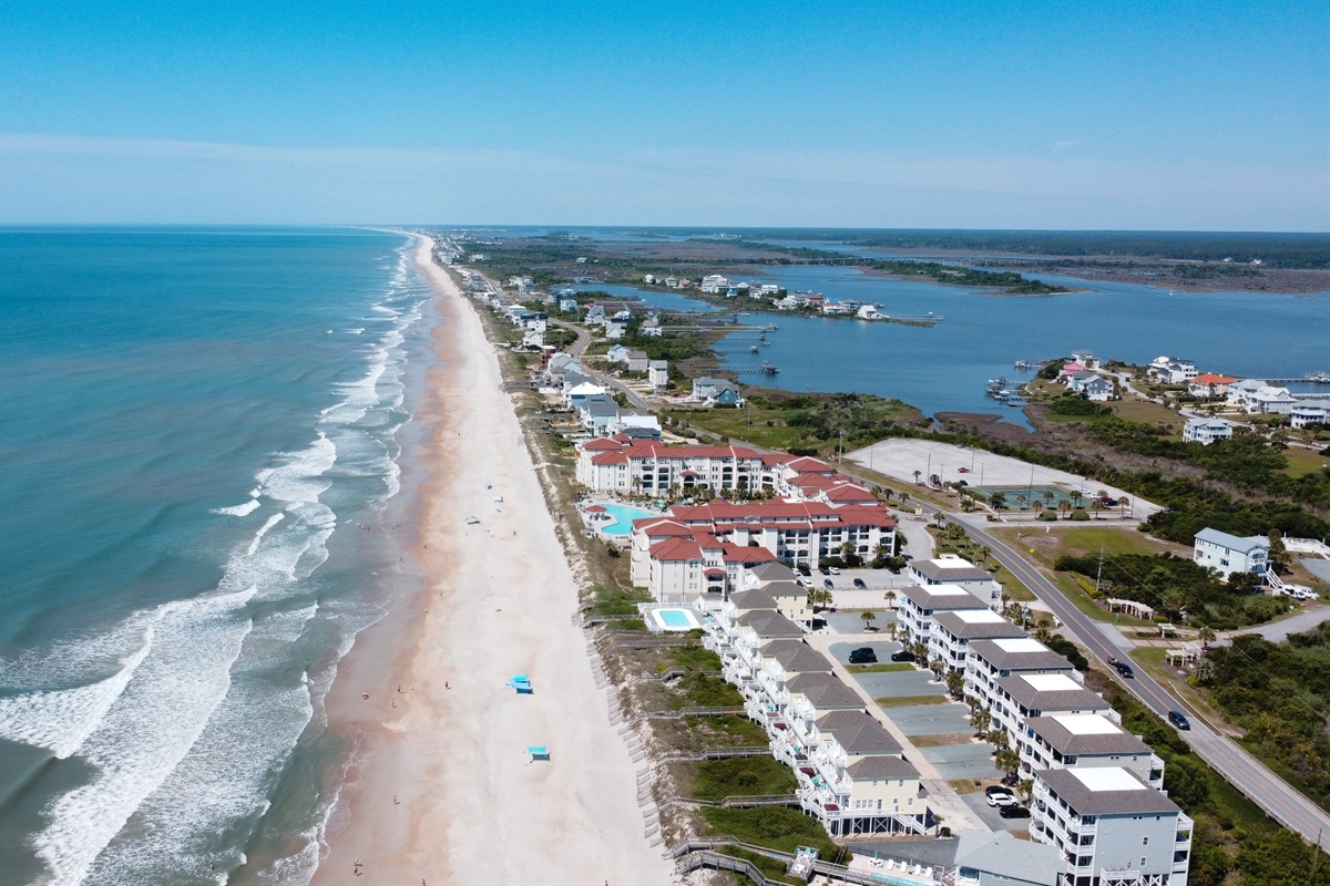 Showcasing residential buildings and a wide expanse of sandy beach.