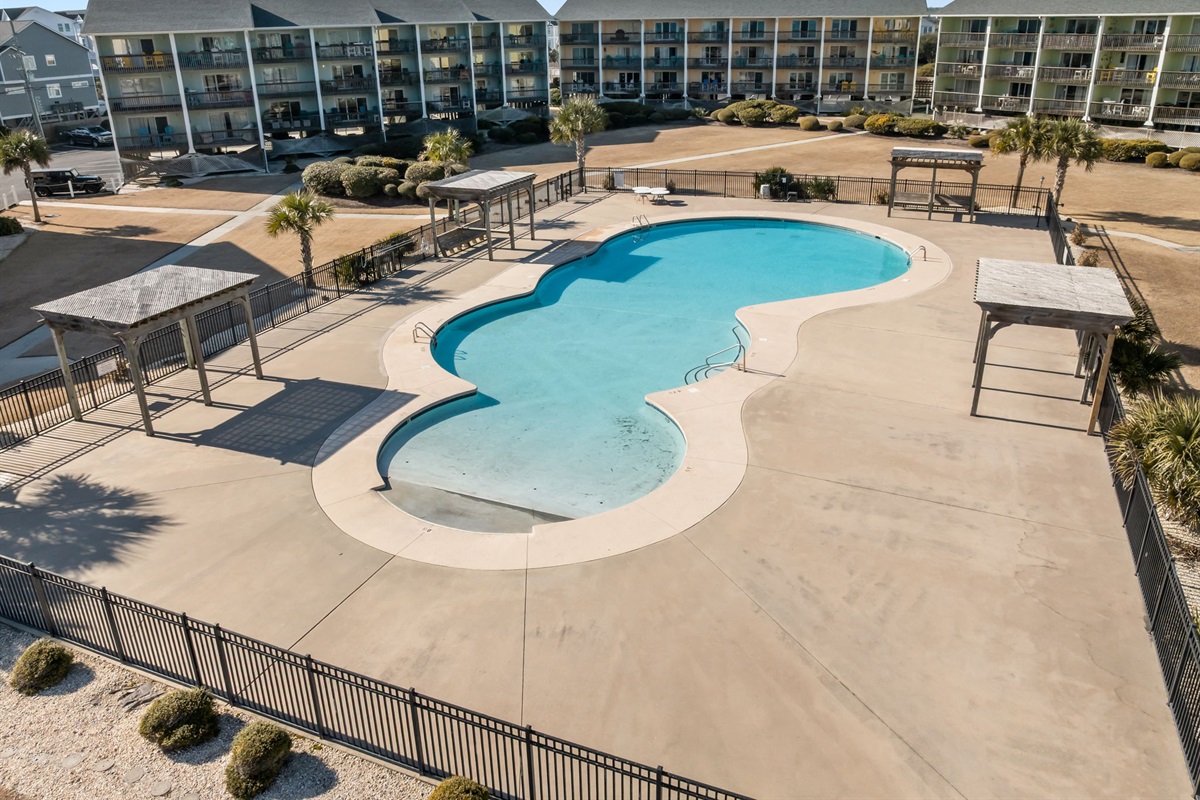 Surf Condos&rsquo; seasonal outdoor pool with spacious deck and seating