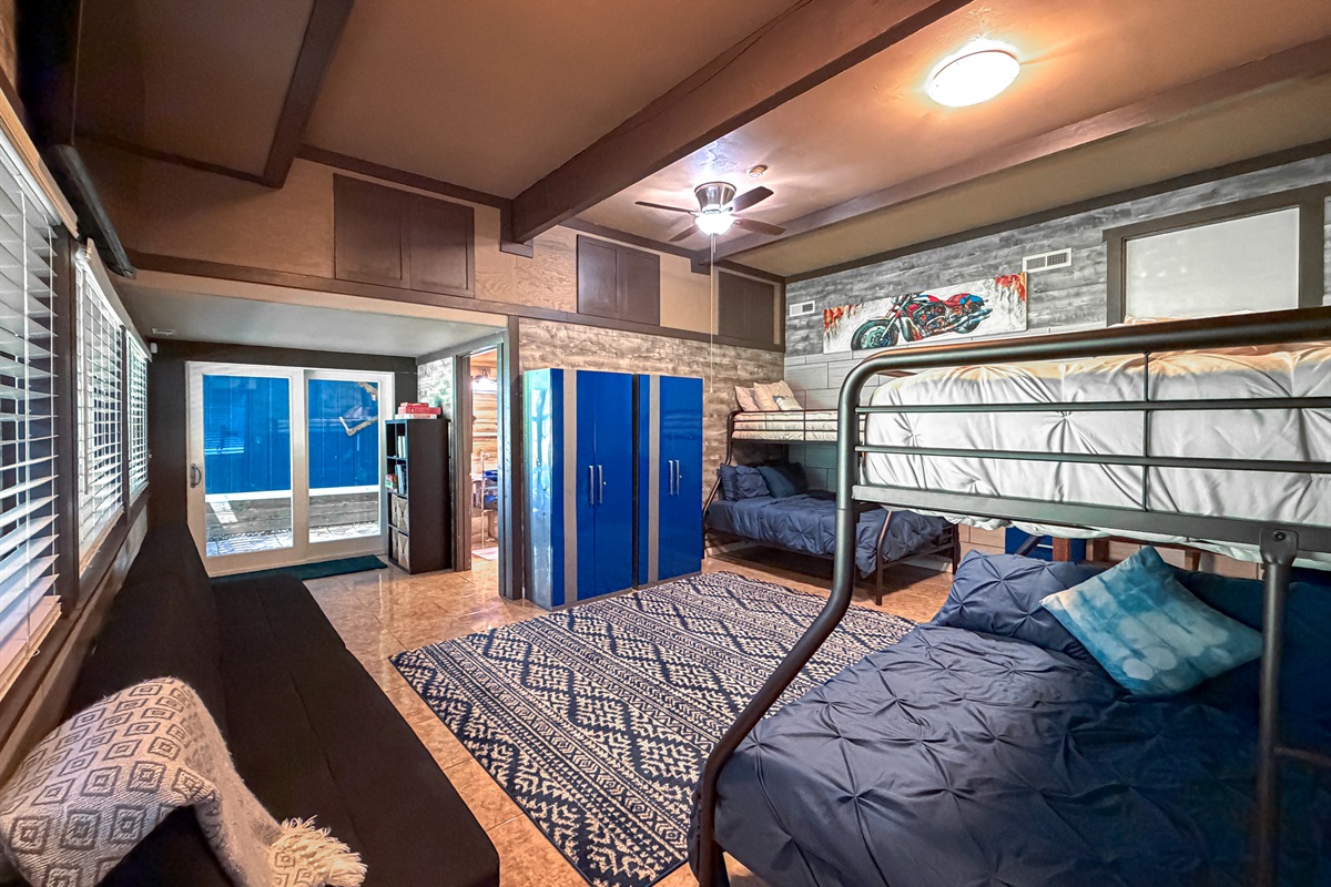 Downstairs Bonus Space featuring pull-out futons for extra guests and a sliding glass door with easy beach access—perfect for enjoying the waterfront lifestyle.