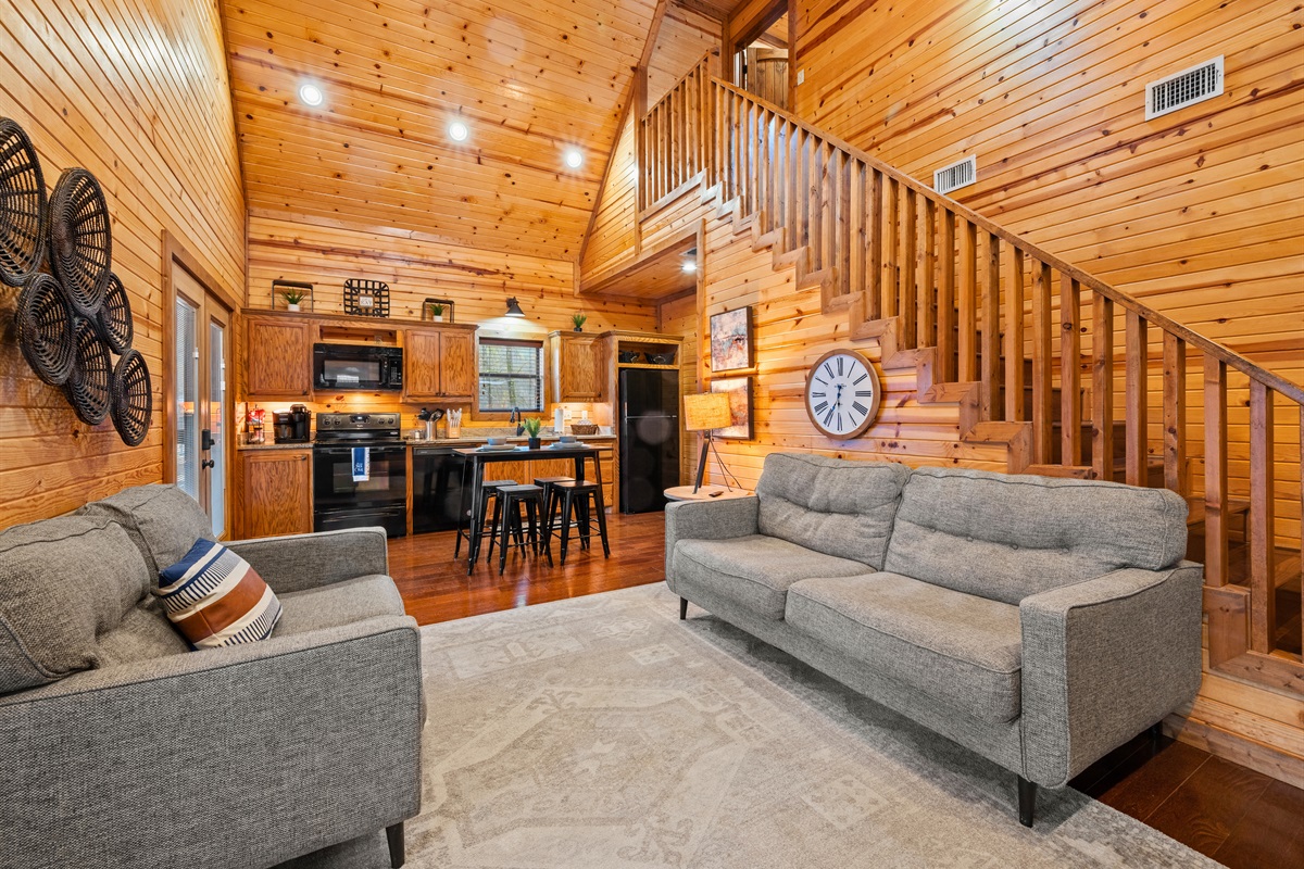 This wide view of the main living area showcases the vaulted ceilings and rustic charm throughout the cabin.