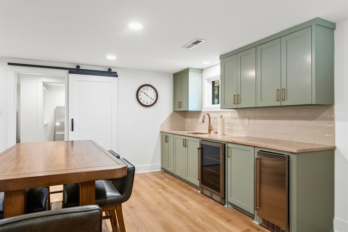 A convenient kitchenette and bar area downstairs makes it easy to grab drinks, prepare snacks, or entertain in the second living space.