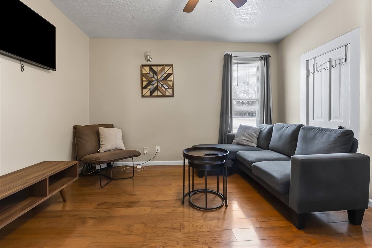 Inviting living room featuring a comfortable couch, sleek mini center table, and a flat-screen TV for your relaxation.