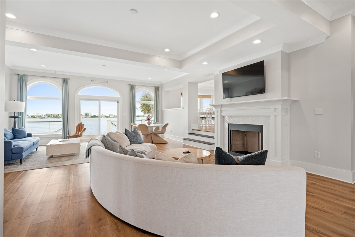 Open-concept main living area with stylish coastal d&eacute;cor and sweeping waterfront views throughout