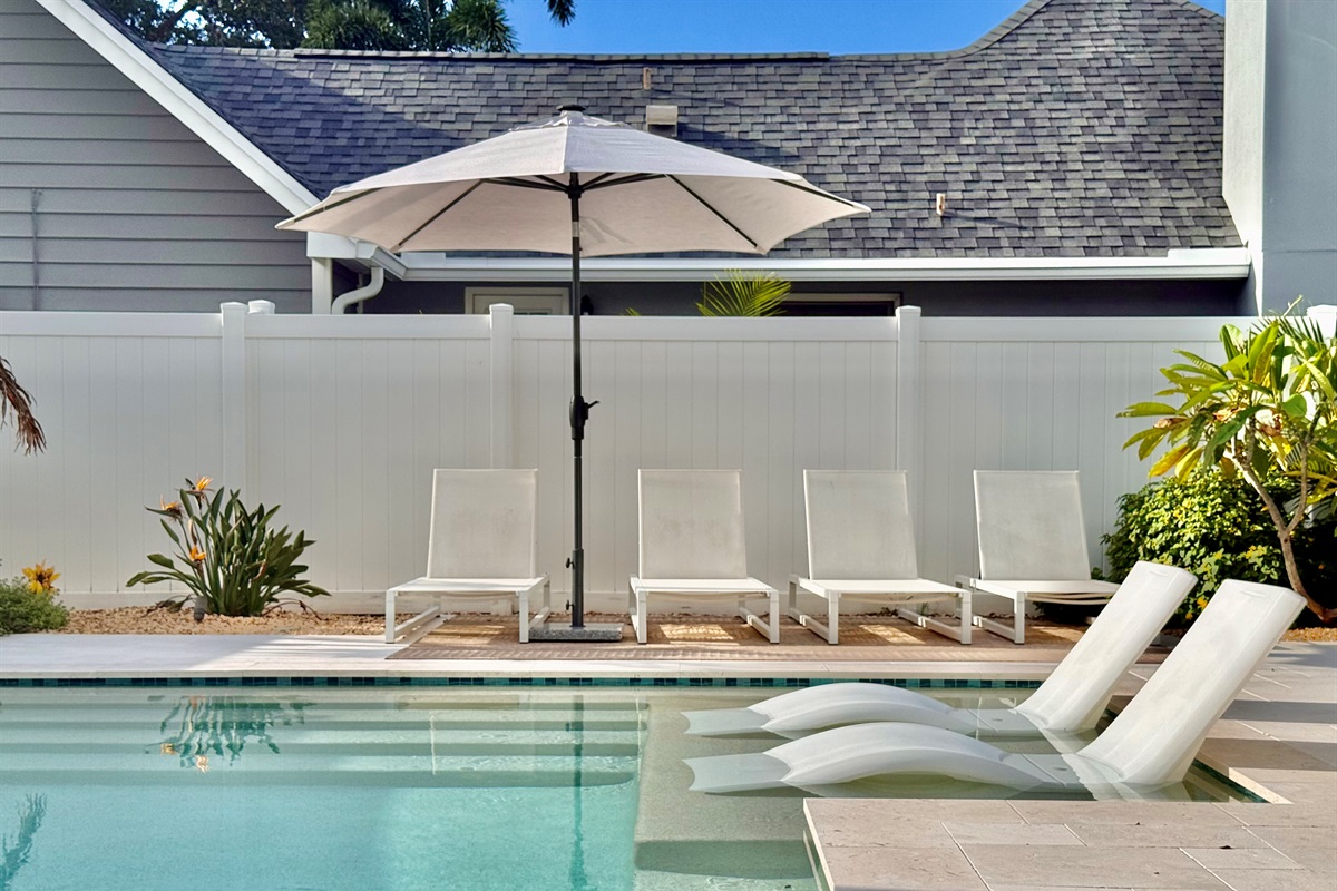 Dive into the turquoise waters of your heated pool, surrounded by privacy fencing and tropical plants.
