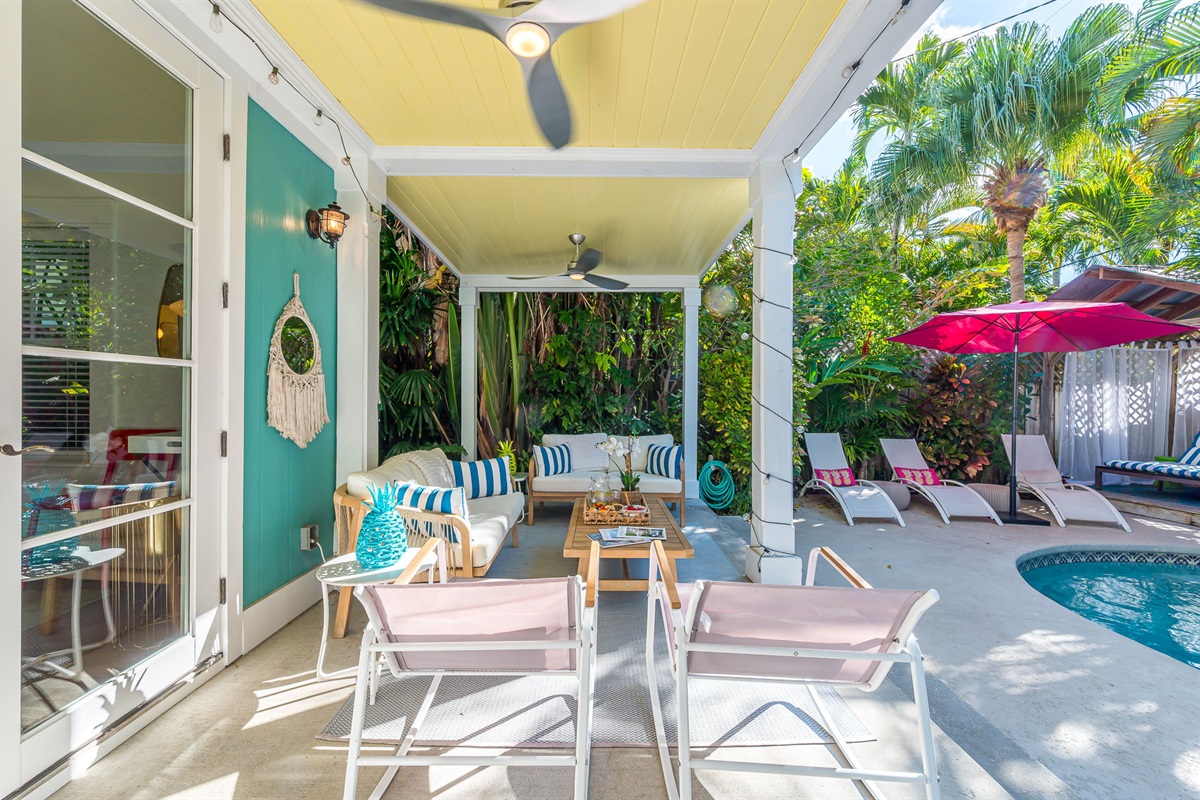 Step into your private tropical oasis featuring a heated pool, sun loungers, an outdoor shower, and a romantic string-lit cabana. Enjoy relaxing or entertaining under the covered patio with comfortable seating and dining, and magnificent pool views.