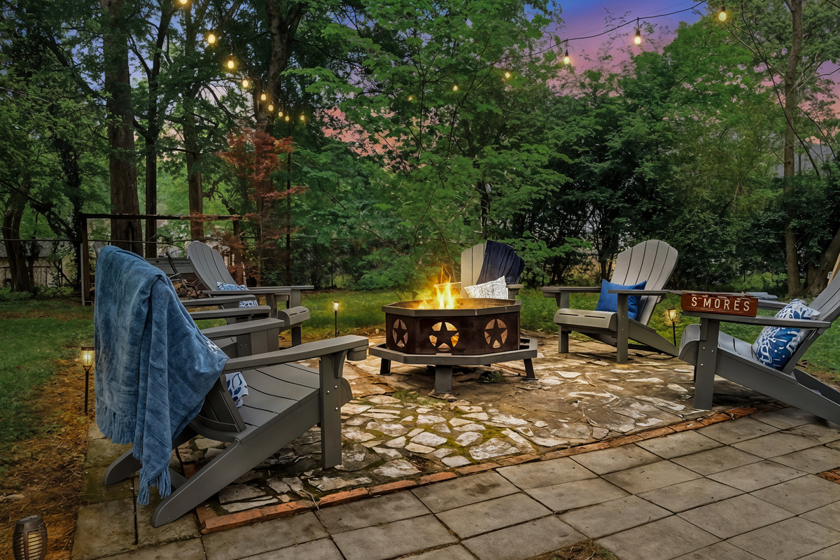 Gather at the firepit as the string lights flick on — marshmallows toasting, the whole group pulled into one circle. After a day at Oaklawn, this is where the night lands.