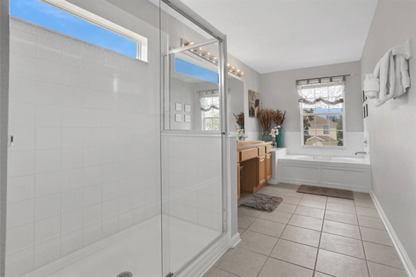 Master bathroom with double vanities, shower booth and soaking bath tub