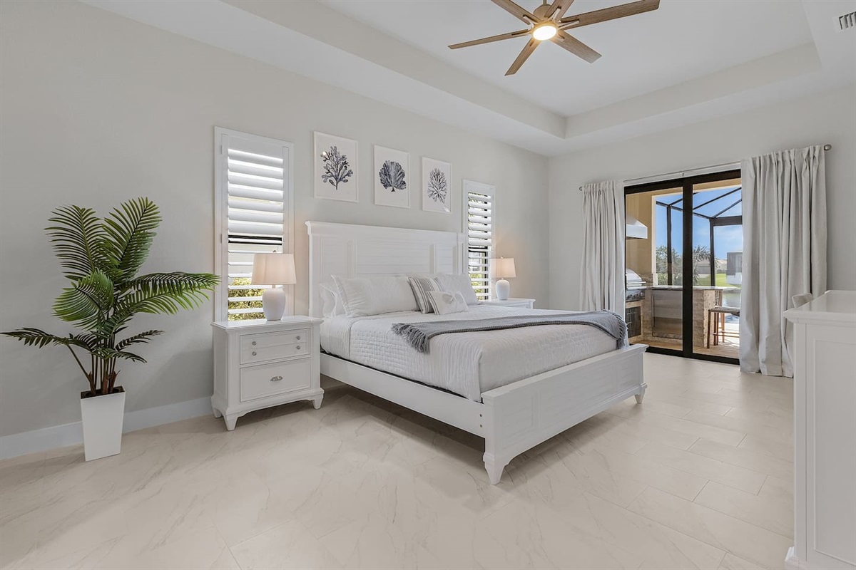 Experience coastal elegance in the primary suite, featuring a TV and seamless access to the pool and spa area, ensuring a tranquil retreat just steps away!