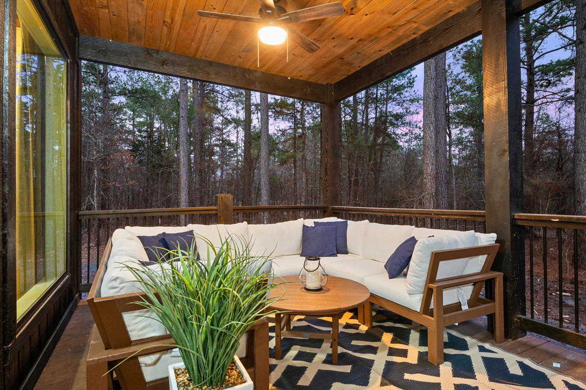This covered patio is a cozy outdoor retreat, perfect for quiet mornings or evening conversations.