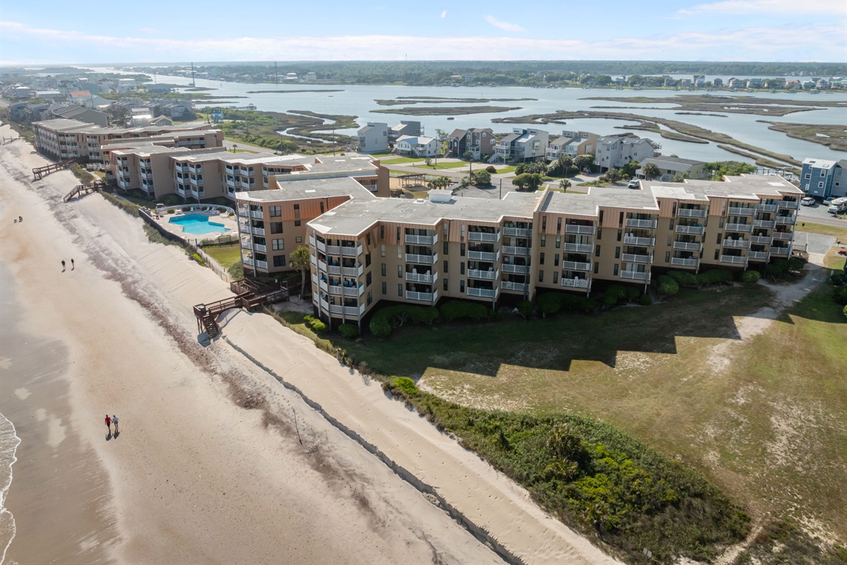 Corner building perspective highlighting direct beach access and the inviting community pool