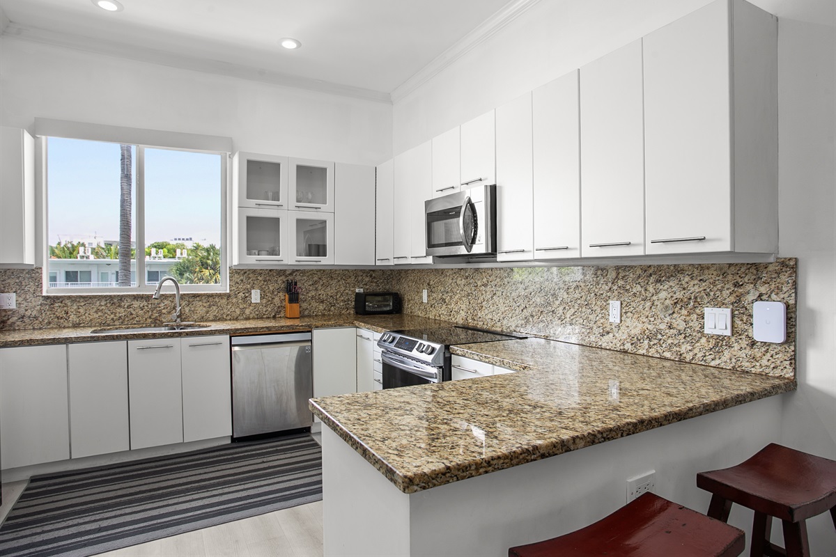 Chef's kitchen with dual-basin sink and breakfast counter. LG laundry tower right next to it.