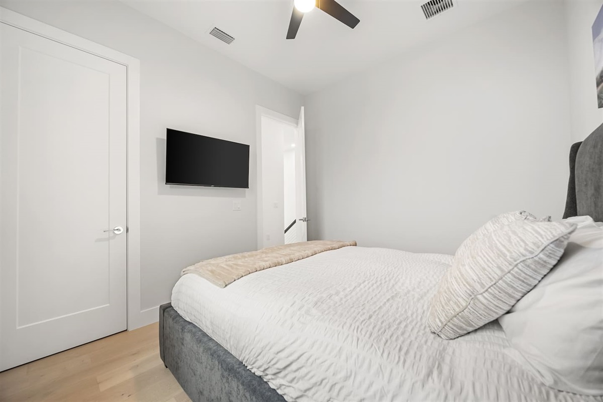 This bedroom features a TV, offering guests the perfect space to unwind with their favorite shows or movies in a comfortable and private setting.