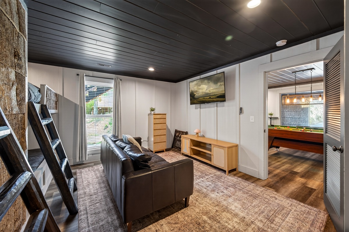 TV, sofa and storage in bunk room.