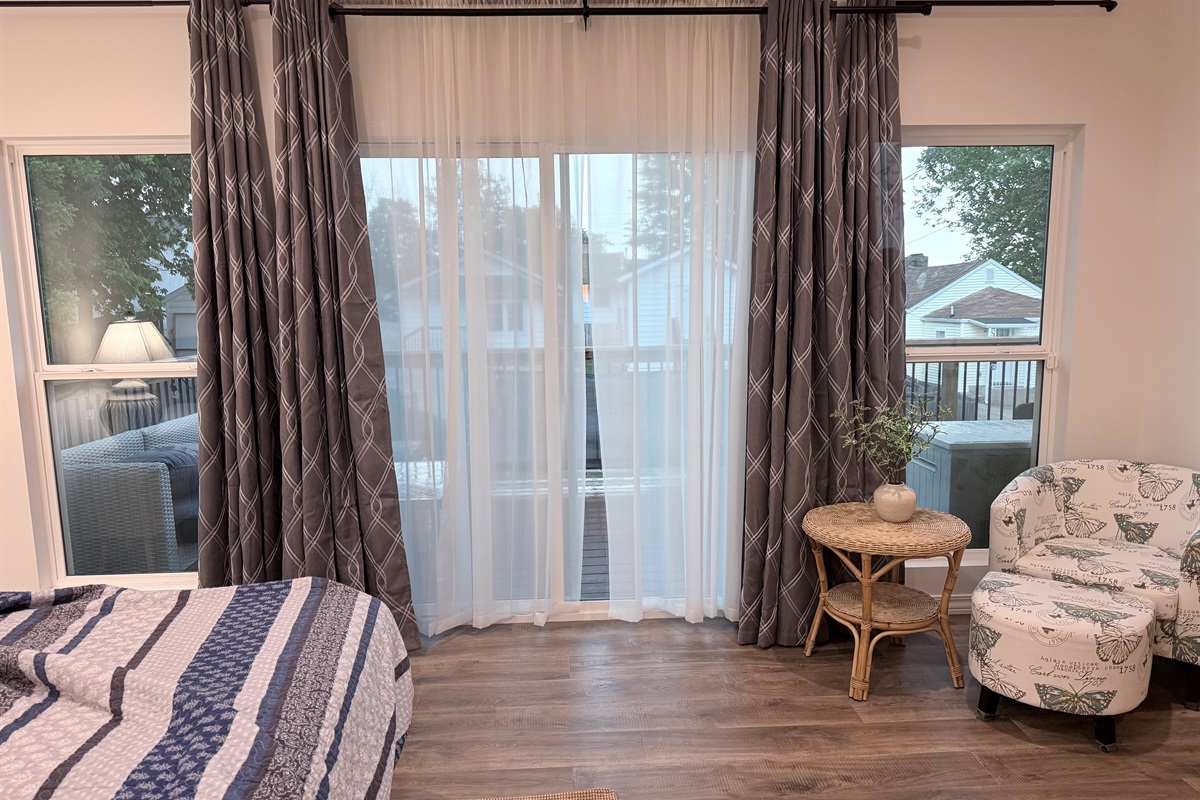 View of large glass windows in master bedroom leading to 10 by 25' composite deck with view of downtown,
