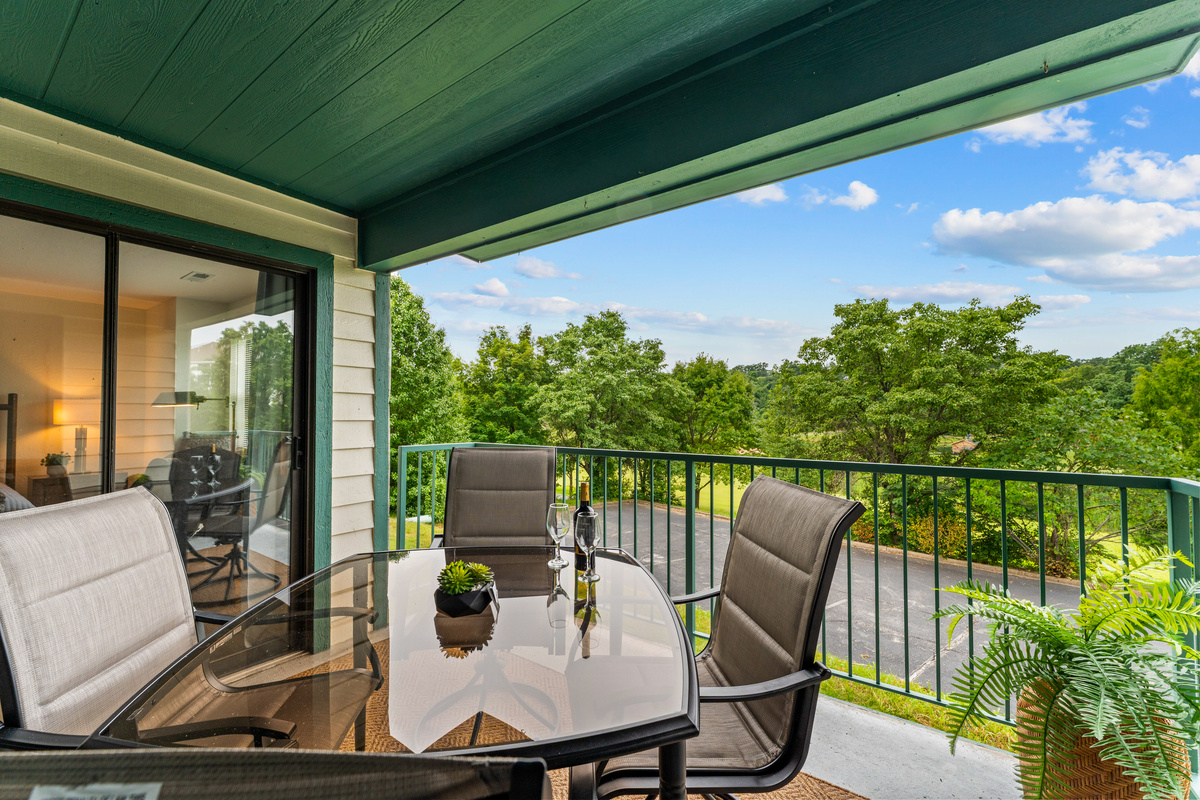 The private covered balcony seats four and opens from both the living room and primary bedroom.
