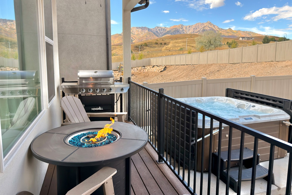 Outdoor deck with private hot tub and BBQ grill — unwind while soaking up scenic mountain views.
