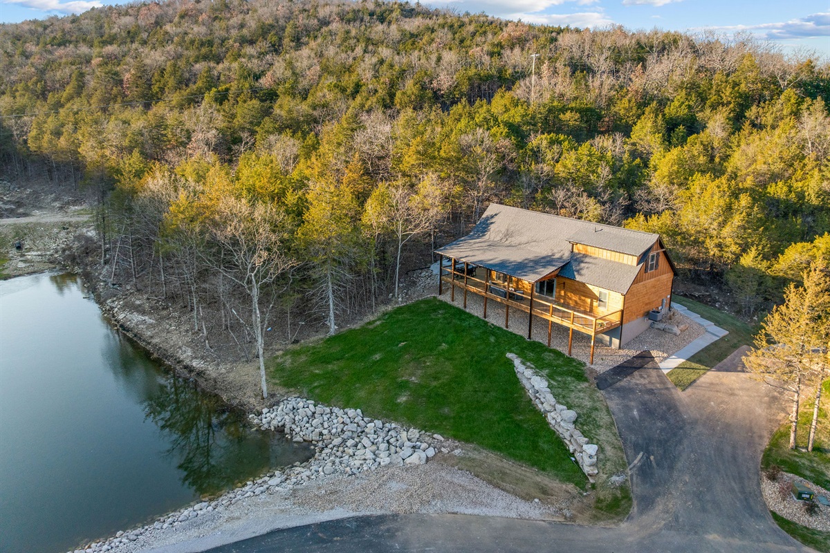 The cabin tucked near the water’s edge and wooded shoreline.