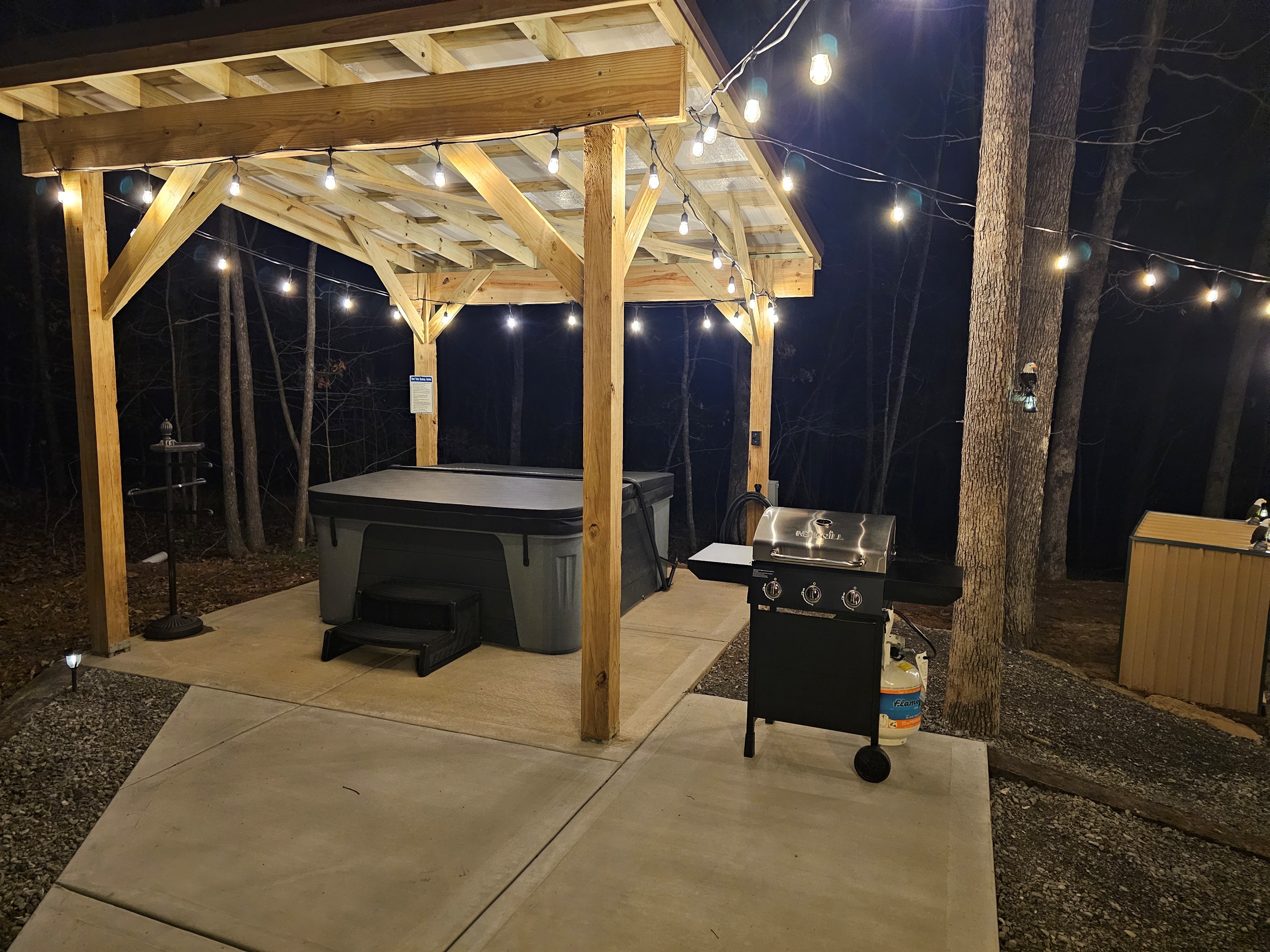 Enjoy your own private outdoor retreat with a covered hot tub, string lights, and gas grill—ideal for evening cookouts and relaxing nights