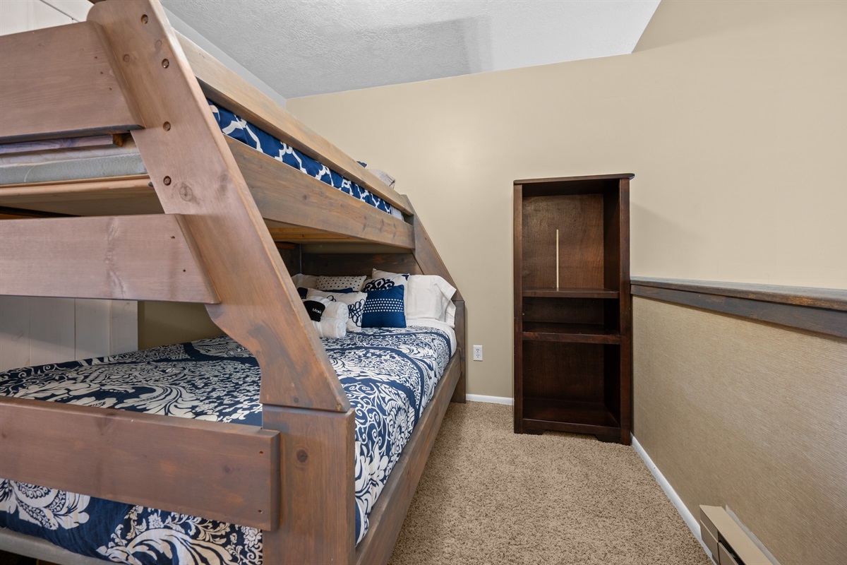 Cozy bunk area with comfortable bedding and nearby storage space.