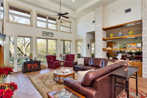 Bright living room with high ceilings, comfortable seating, and views of the porch and ranch area. Designed for guests to feel welcomed and at home, after an adventurous day on the lake or at the golf course!