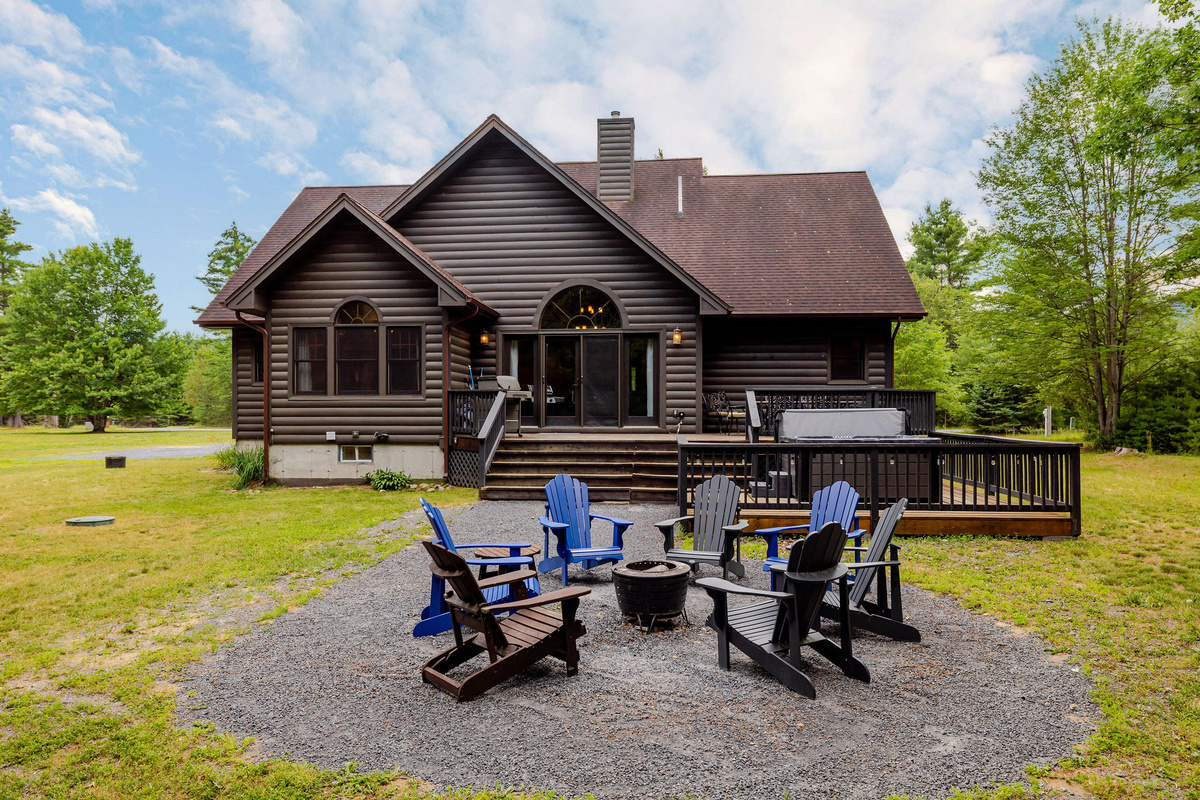 Gather around the fire pit, soak in the hot tub, or relax on the spacious deck surrounded by peaceful Adirondack woods.