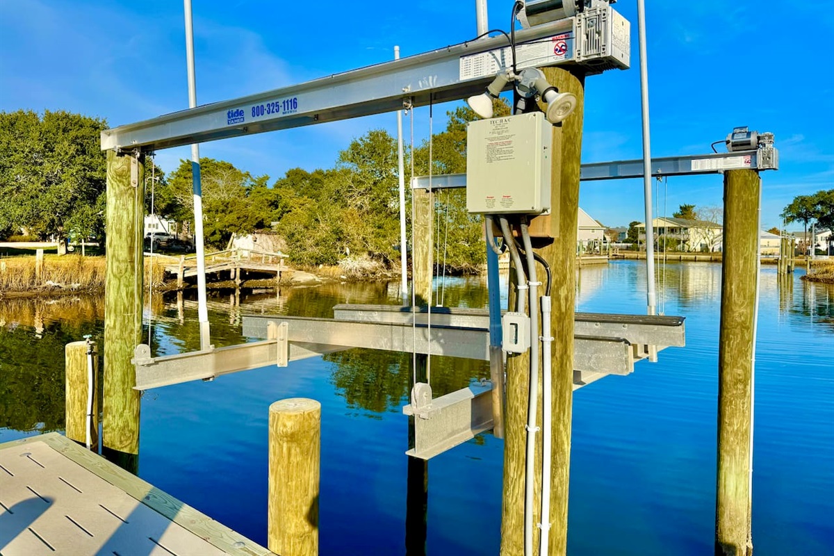 Private backyard dock with boat lift and fillet table, fenced-in backyard, fire pit with Adirondack chairs, hammocks, propane grill, picnic table, outdoor shower, expansive waterfront back deck with table and seating, neighborhood boat ramp and dock