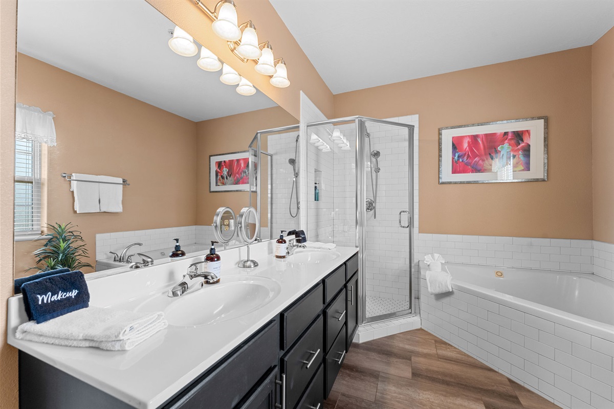 The attached primary ensuite bathroom with double vanity, walk in shower and large jetted tub