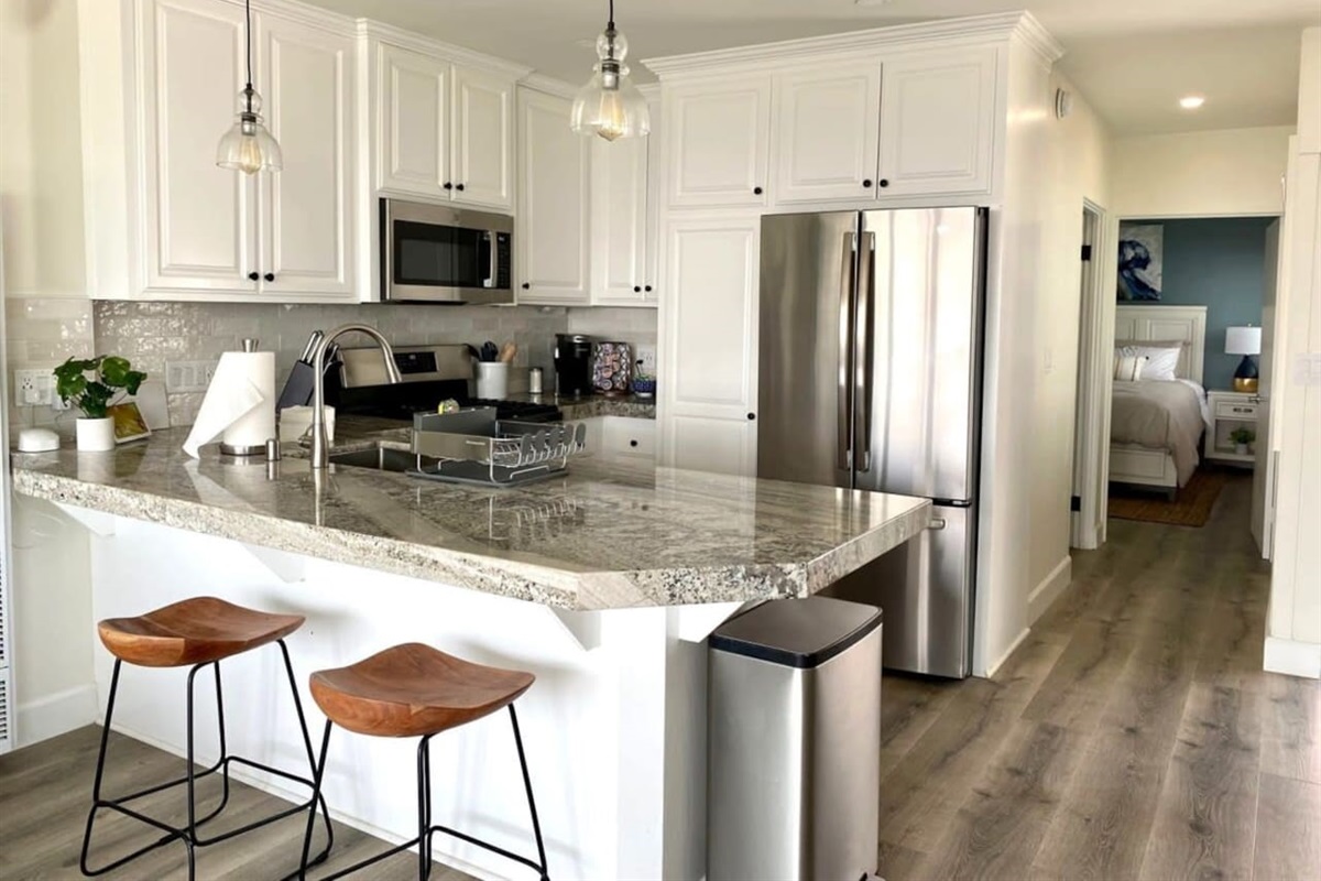 Walking back through the kitchen is the bathroom on the right and the bedroom at the end of the hall.