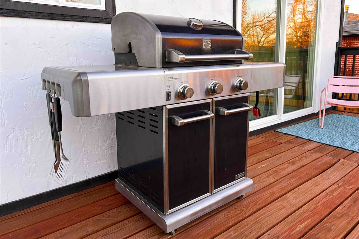 Propane grill for enjoying the backyard and relaxing in for dinner. BBQ tool set: tongs, spatula, grill brush.