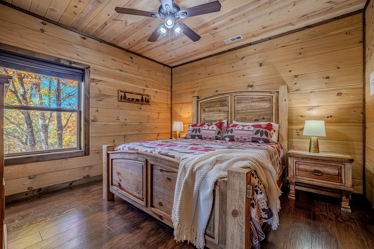 Bright king bedroom with rustic furniture and natural light.