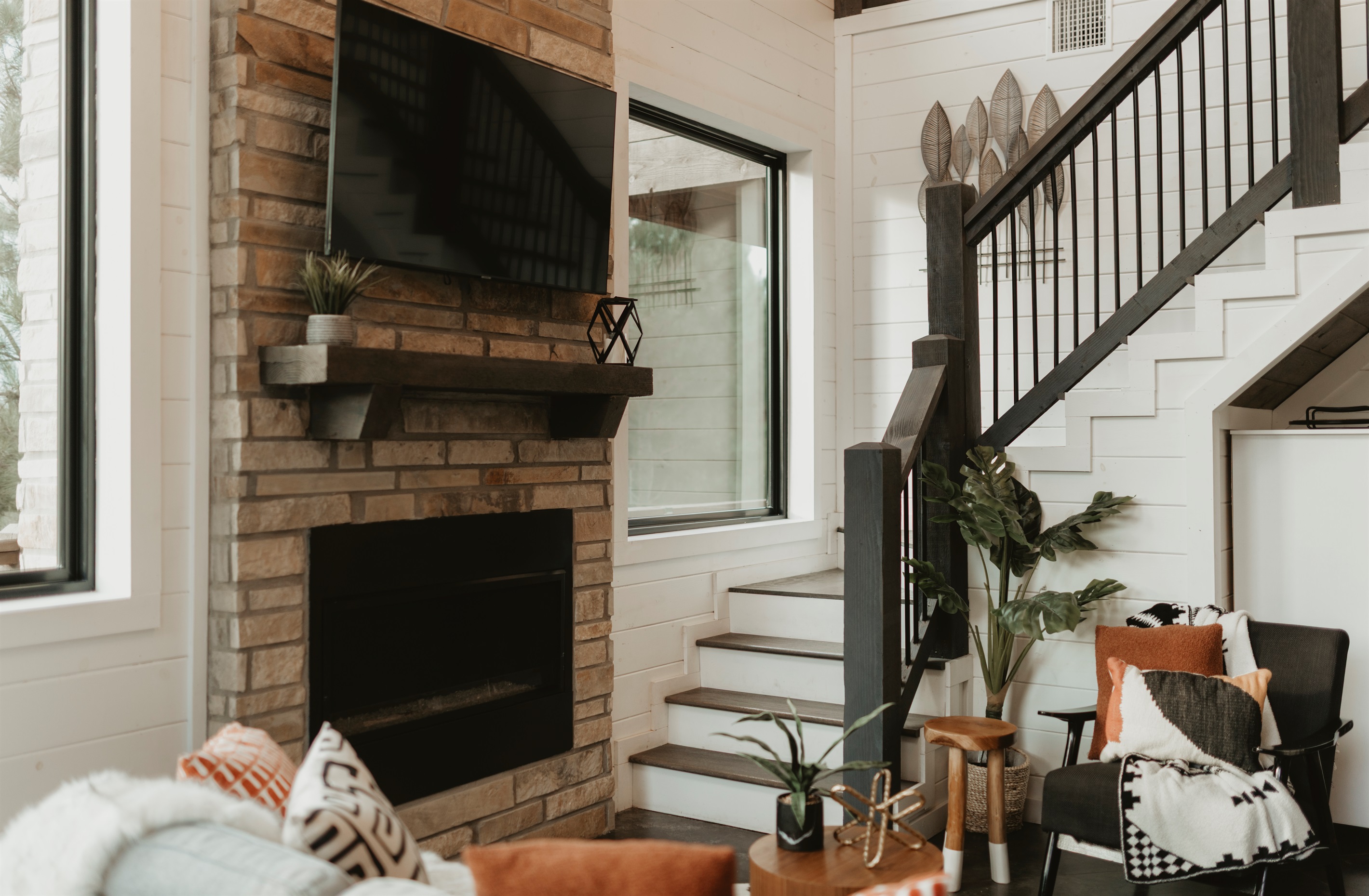 Stylish and cozy—this living room pairs a stone fireplace, plush seating, and forest views with modern cabin charm. Gather here for movie nights, fireside chats, or simply relaxing together after a day of adventure.