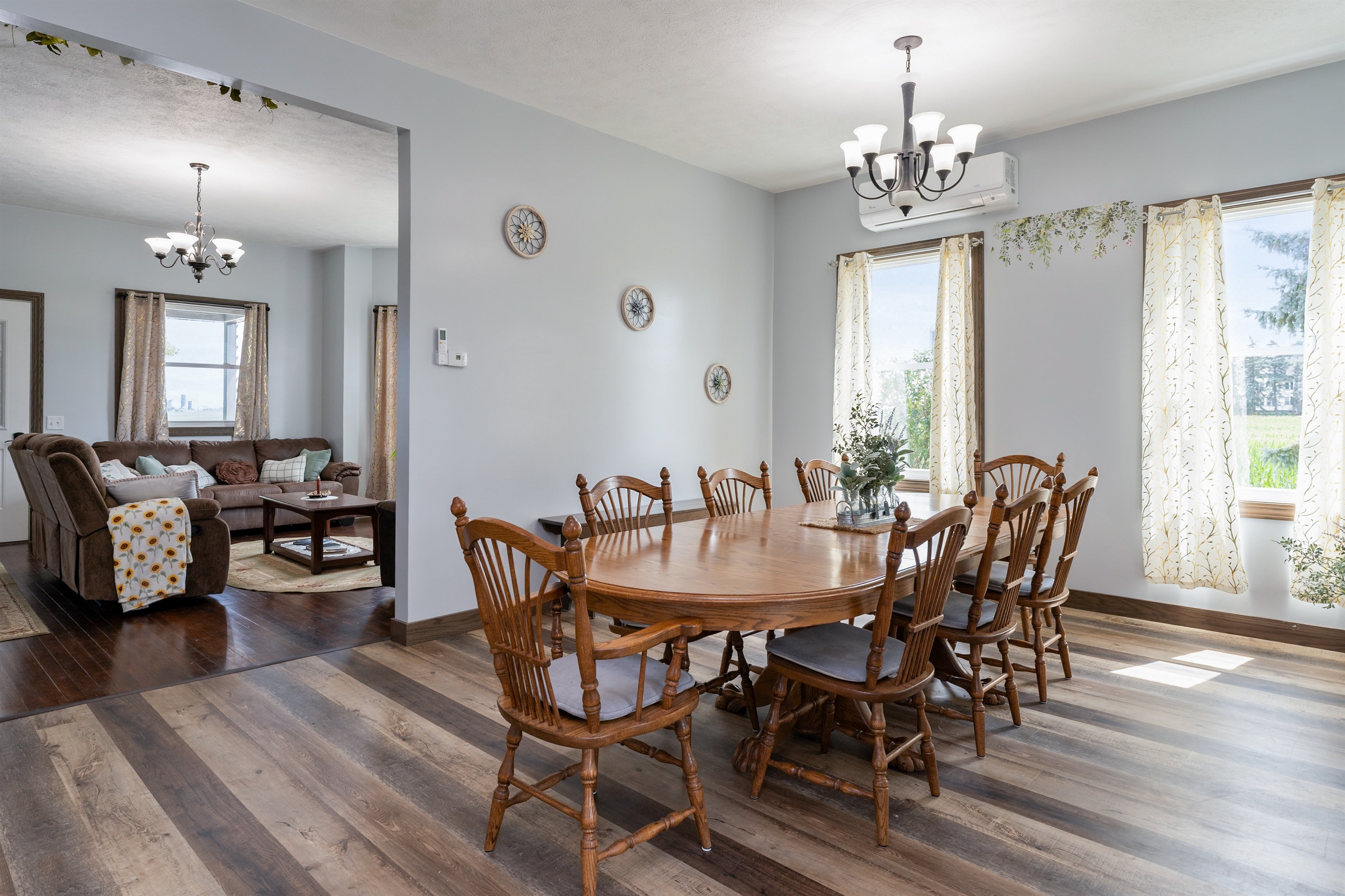 Bright and airy dining space featuring large windows, elegant curtains, and a spacious wooden table perfect for family meals or gatherings.